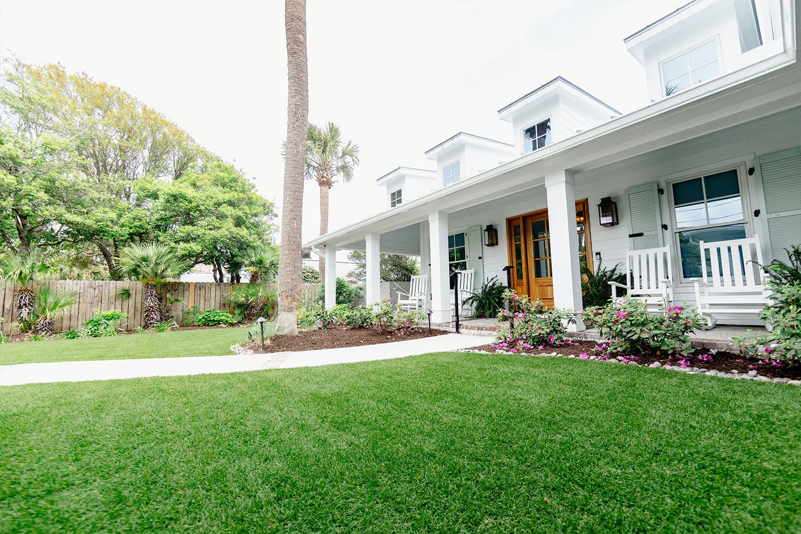 Residential yard with artificial turf bordered by landscaping