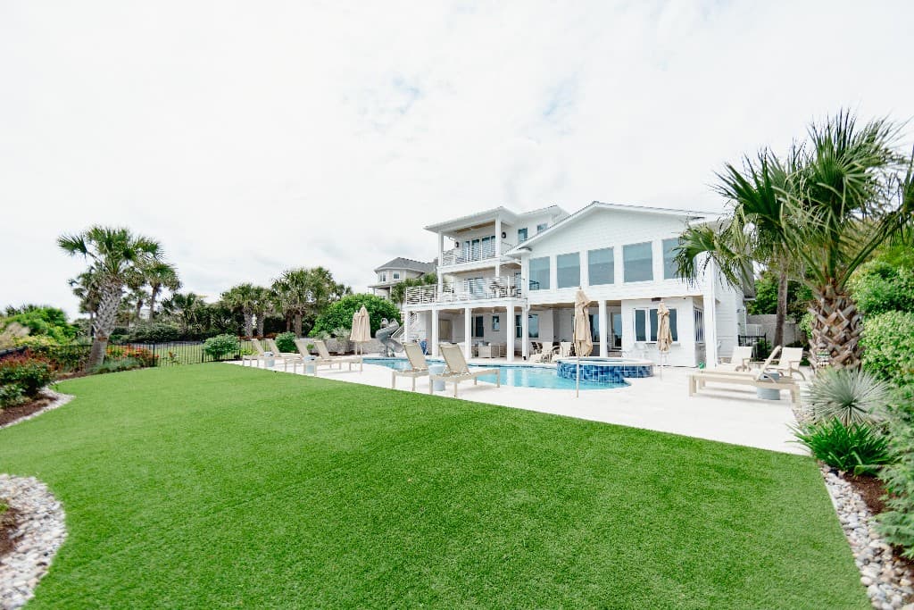 Coastal home with a manicured artificial turf lawn
